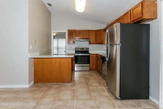 a kitchen with stainless steel appliances granite countertop a refrigerator and a stove