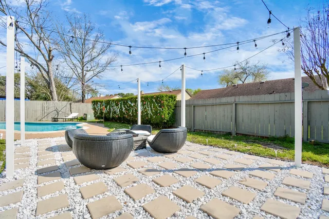 a view of a backyard with table and chairs potted plants