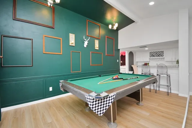 a room with pool table and windows
