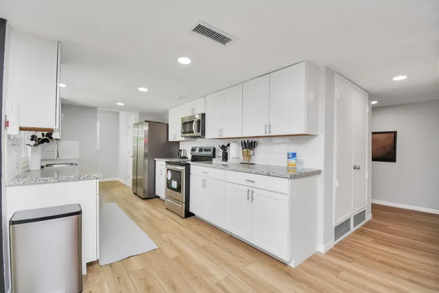 a kitchen with stainless steel appliances a refrigerator sink and cabinets