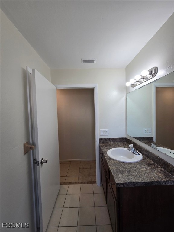 4803 Triton Court East, Unit 2 Cape Coral, FL 33904 - Photo 11 of 18 a bathroom with a granite countertop sink and a mirror