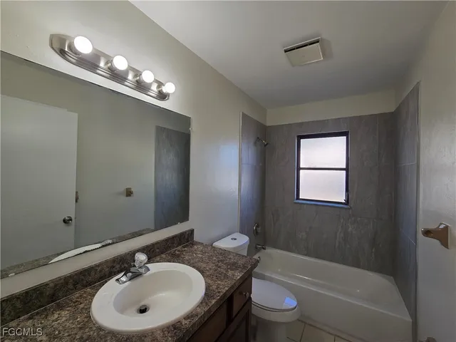 a bathroom with a sink double vanity granite tub and a mirror