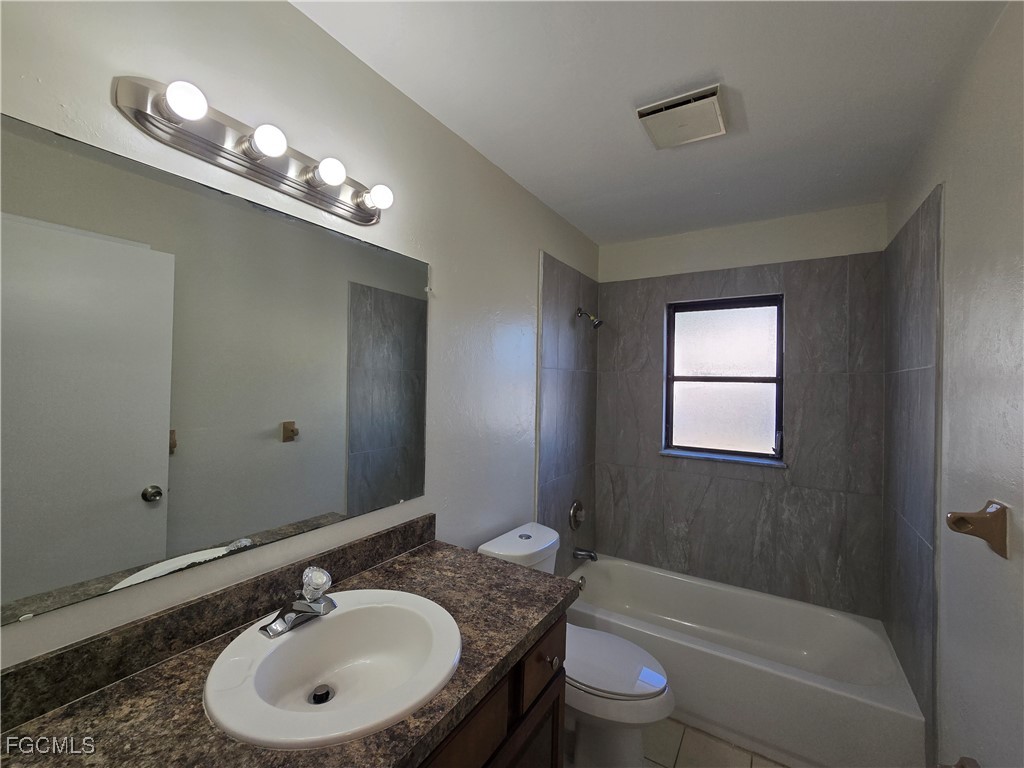 4803 Triton Court East, Unit 2 Cape Coral, FL 33904 - Photo 13 of 18 a bathroom with a sink double vanity granite tub and a mirror