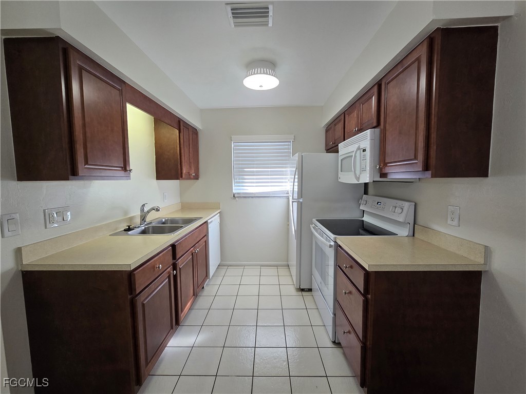 4803 Triton Court East, Unit 2 Cape Coral, FL 33904 - Photo 2 of 18 a kitchen with a sink stove and cabinets