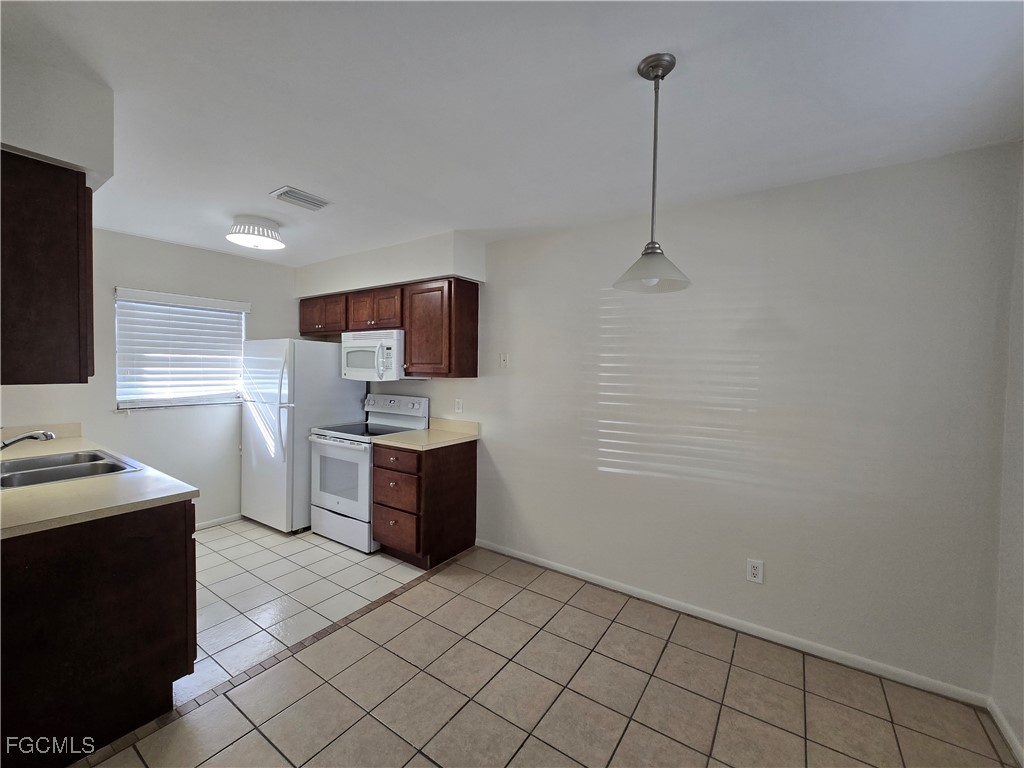 4803 Triton Court East, Unit 2 Cape Coral, FL 33904 - Photo 3 of 18 a kitchen with stainless steel appliances granite countertop a sink stove and refrigerator
