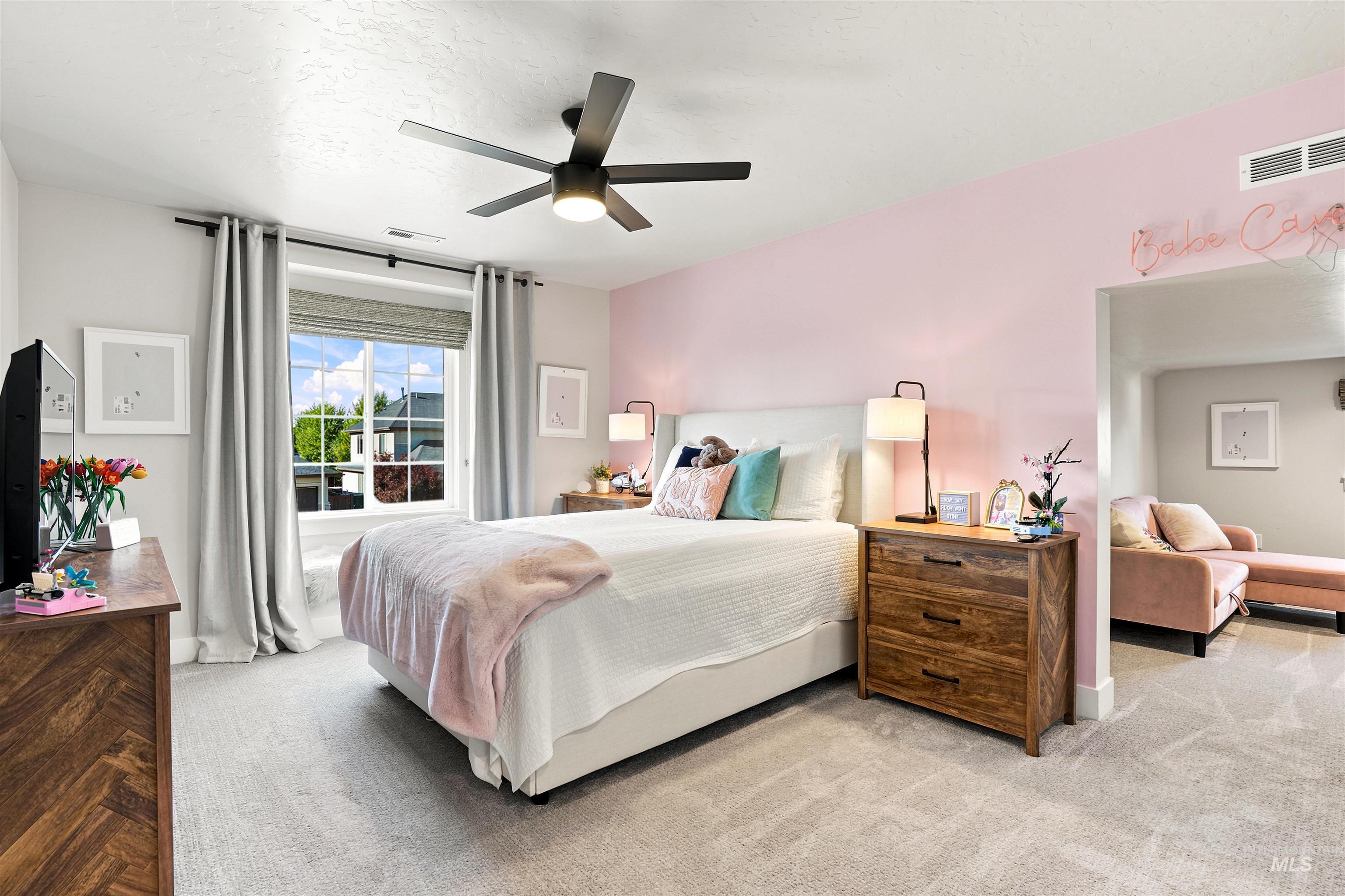 4323 West Ladle Rpds Drive Meridian, ID 83646 - Photo 30 of 49 Spacious bedroom featuring light neutral carpet, a large window with roller shades and curtains, a ceiling fan with integrated lighting, and a recessed opening to an additional room