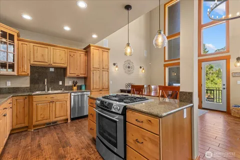 a kitchen that has a sink a stove and wooden floor