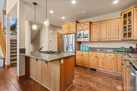 a kitchen with stainless steel appliances granite countertop a stove a sink and a refrigerator