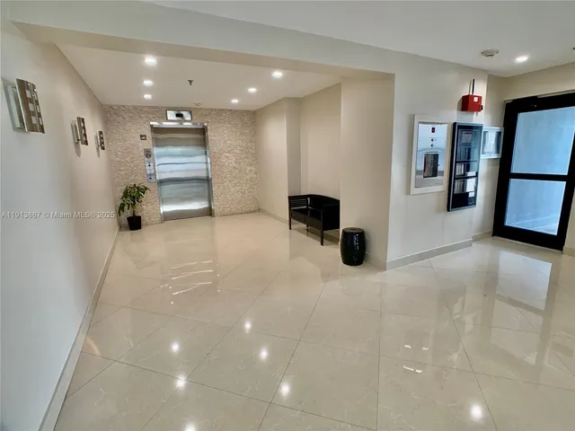 a view of a hallway with a refrigerator and a refrigerator