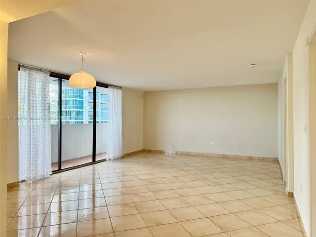 a view of empty room with wooden floor and window