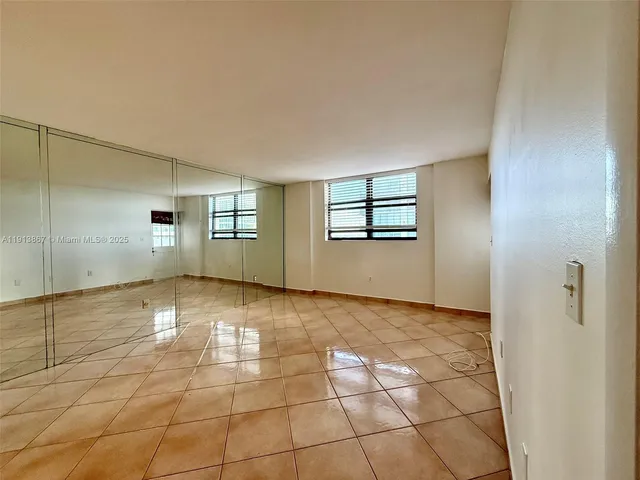 a view of empty room with wooden floor and windows