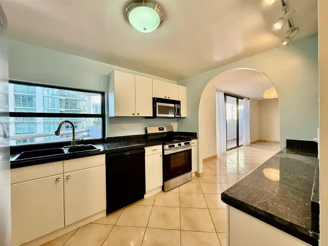 a kitchen with stainless steel appliances granite countertop a sink stove and cabinets