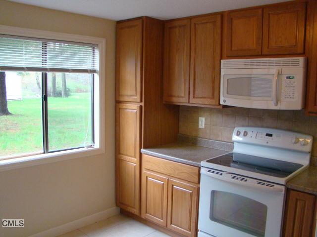 7 Padanaram Road, Unit 217 Danbury, CT 06811 - Photo 1 of 1 a kitchen with granite countertop cabinets stainless steel appliances and a window
