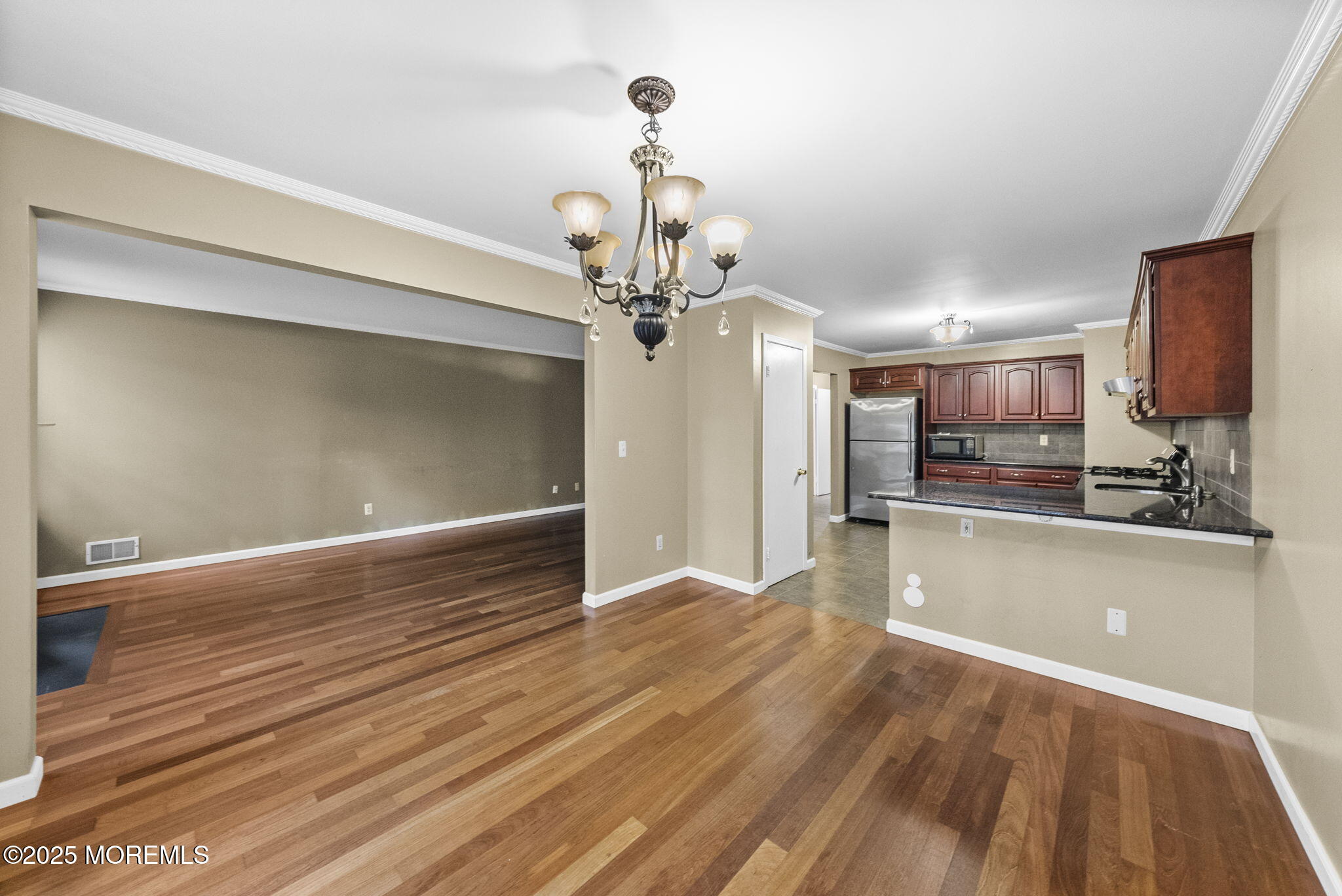 63 Atrium Way, Unit 63 Manalapan, NJ 07726 - Photo 11 of 40 a view of a room with wooden floor and kitchen view