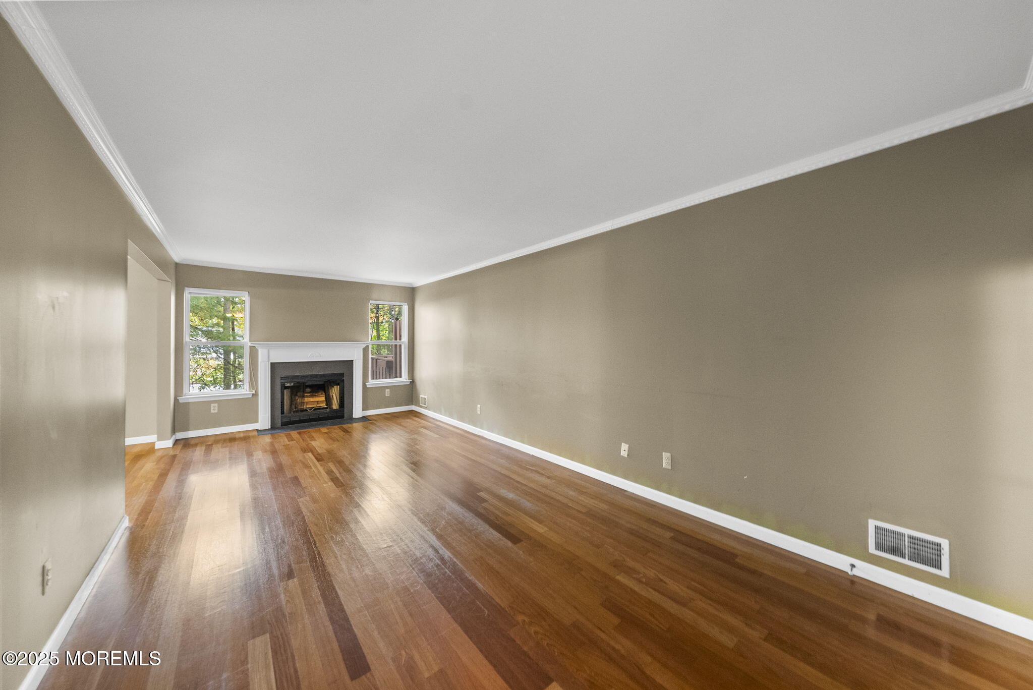 63 Atrium Way, Unit 63 Manalapan, NJ 07726 - Photo 14 of 40 a view of empty room with wooden floor and fireplace