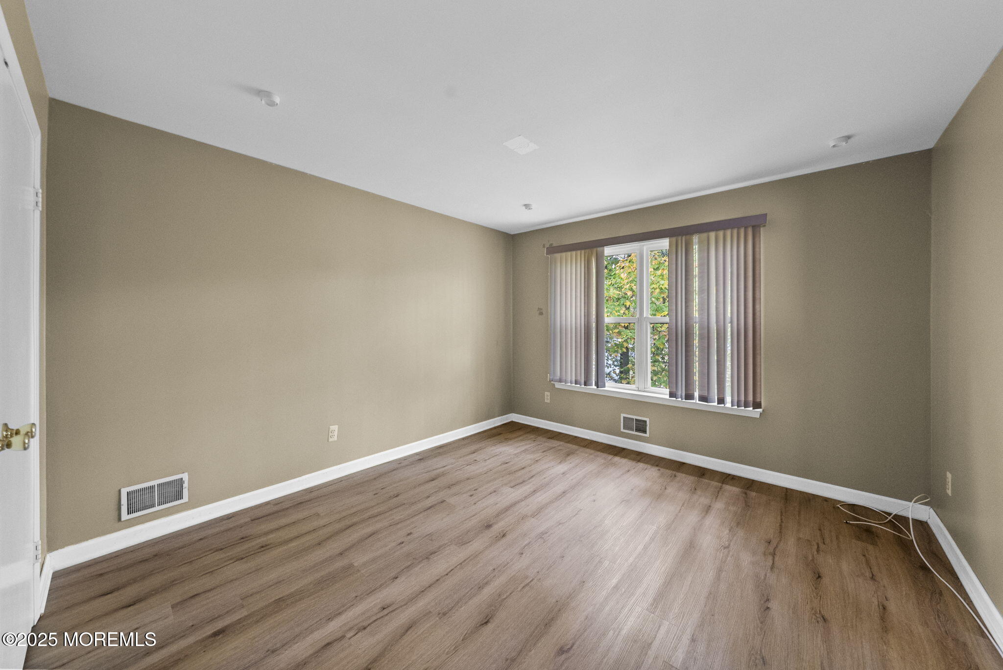 63 Atrium Way, Unit 63 Manalapan, NJ 07726 - Photo 28 of 40 a view of an empty room with wooden floor and a window