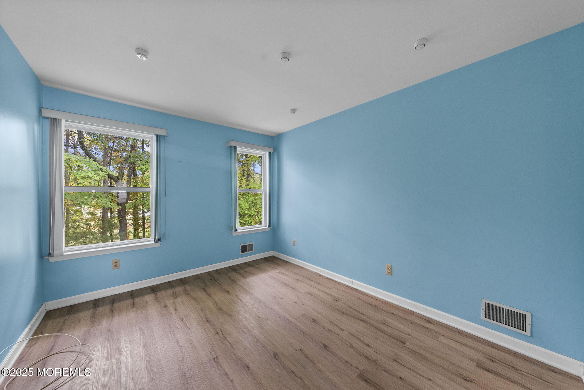 63 Atrium Way, Unit 63 Manalapan, NJ 07726 - Photo 30 of 40 a view of an empty room with wooden floor and a window