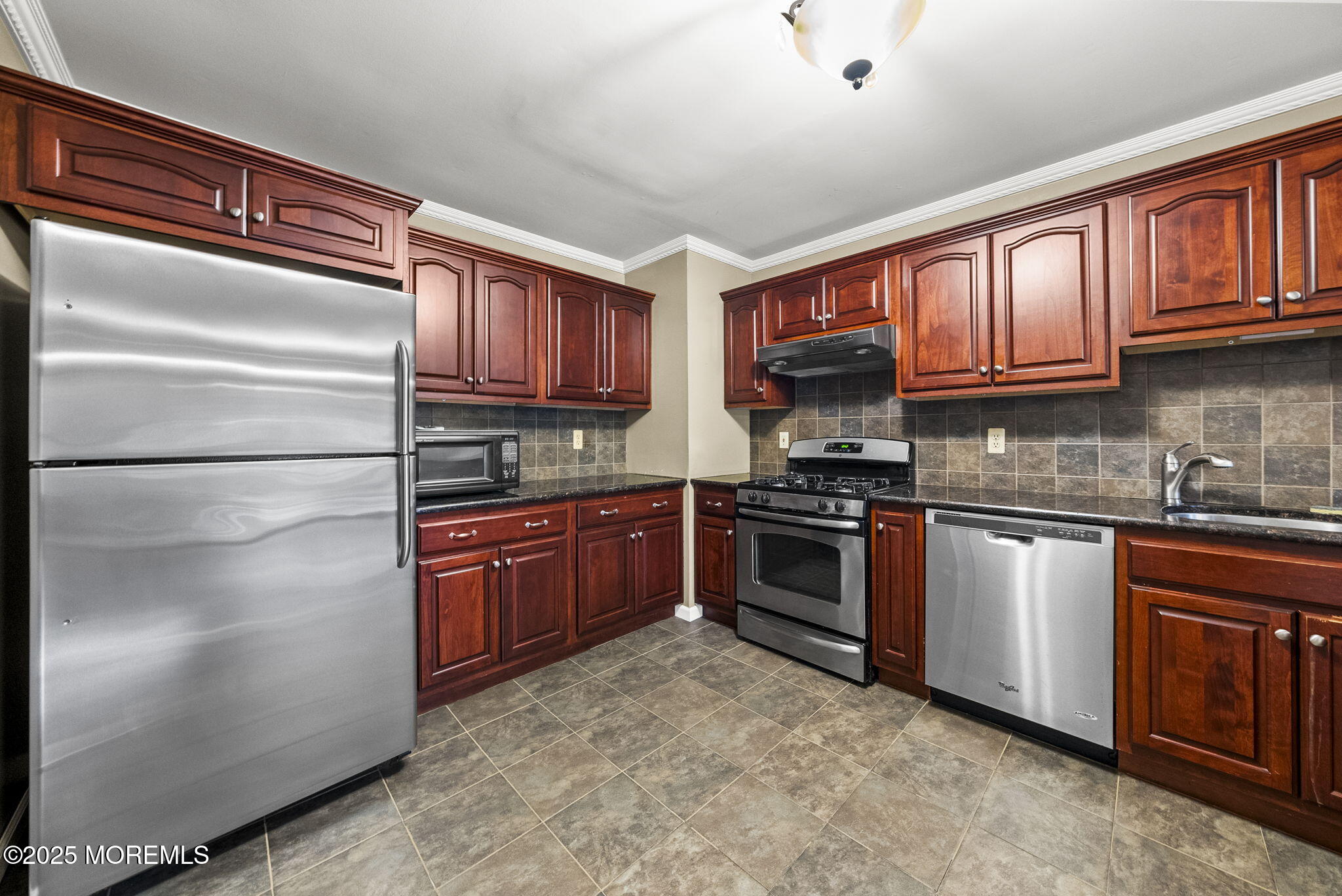 63 Atrium Way, Unit 63 Manalapan, NJ 07726 - Photo 6 of 40 a kitchen with stainless steel appliances granite countertop a refrigerator a stove top oven a sink and dishwasher