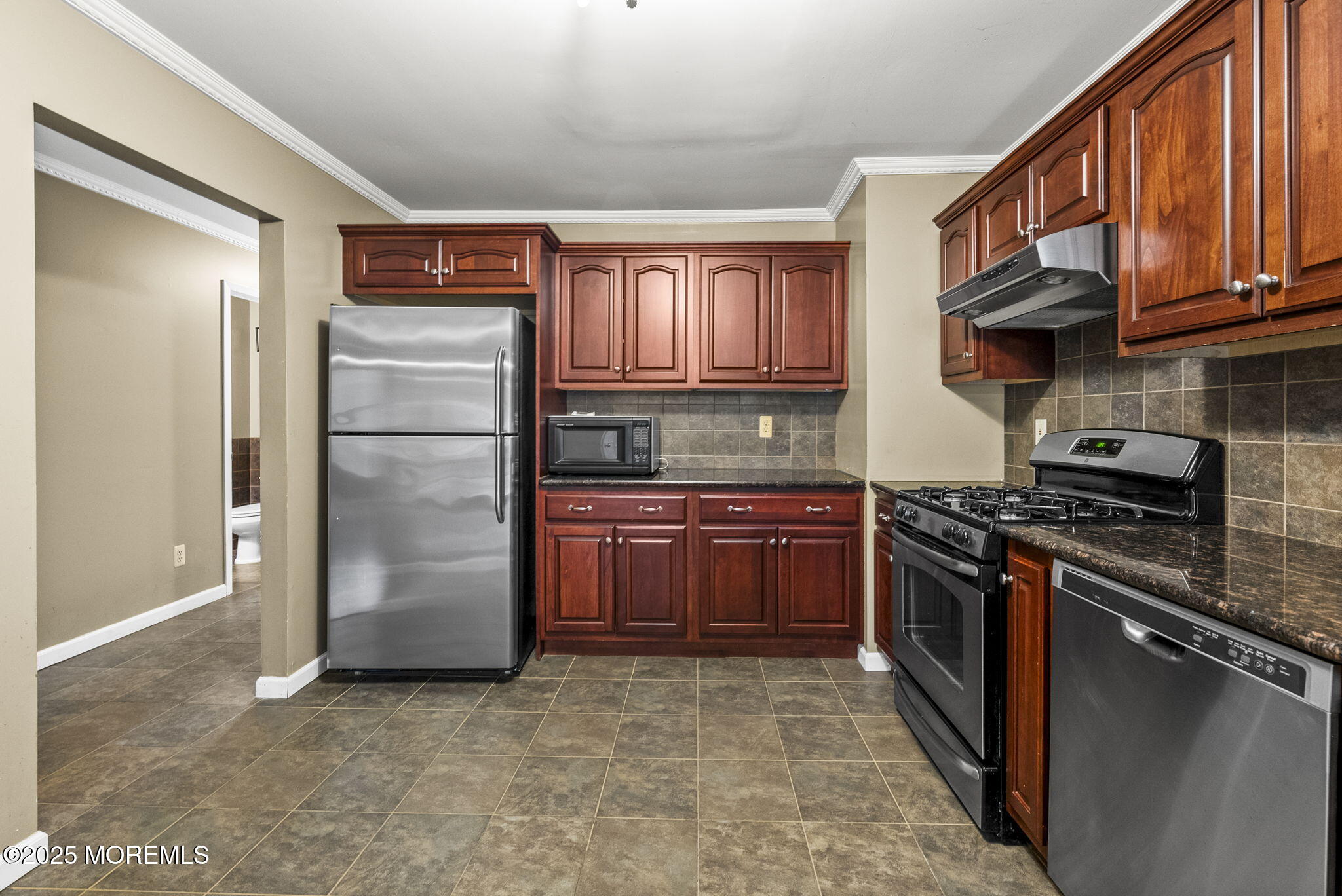 63 Atrium Way, Unit 63 Manalapan, NJ 07726 - Photo 7 of 40 a kitchen with stainless steel appliances granite countertop a washer and dryer