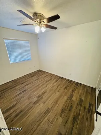 a view of empty room with wooden floor