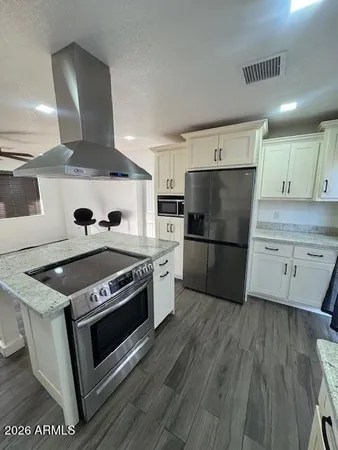 a kitchen with a stove refrigerator and microwave