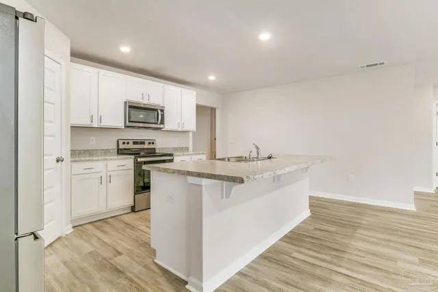 a kitchen with appliances a sink and cabinets