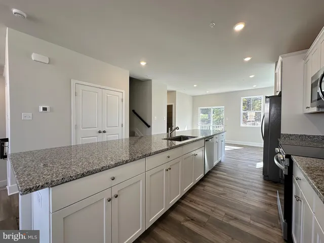 a view of a living room and kitchen with furniture wooden floor and a window