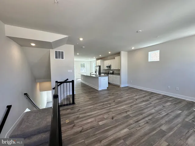 a large kitchen with kitchen island granite countertop a large window and stainless steel appliances