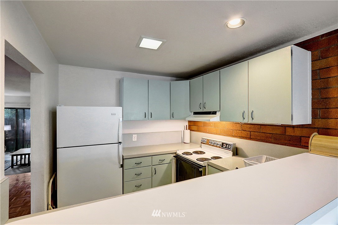 4404 Terrace Drive, Unit 3 Everett, WA 98203 - Photo 16 of 18 a kitchen with stainless steel appliances granite countertop a refrigerator sink and cabinets