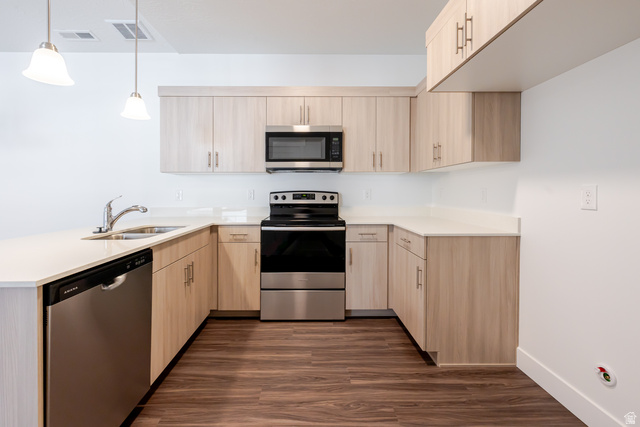 4662 Poplar Way, Unit Q303 Mapleton, UT 84664 - Photo 5 of 18 Kitchen with stainless steel appliances, a peninsula, light wood finish cabinets, dark wood-style flooring, and pendant lighting