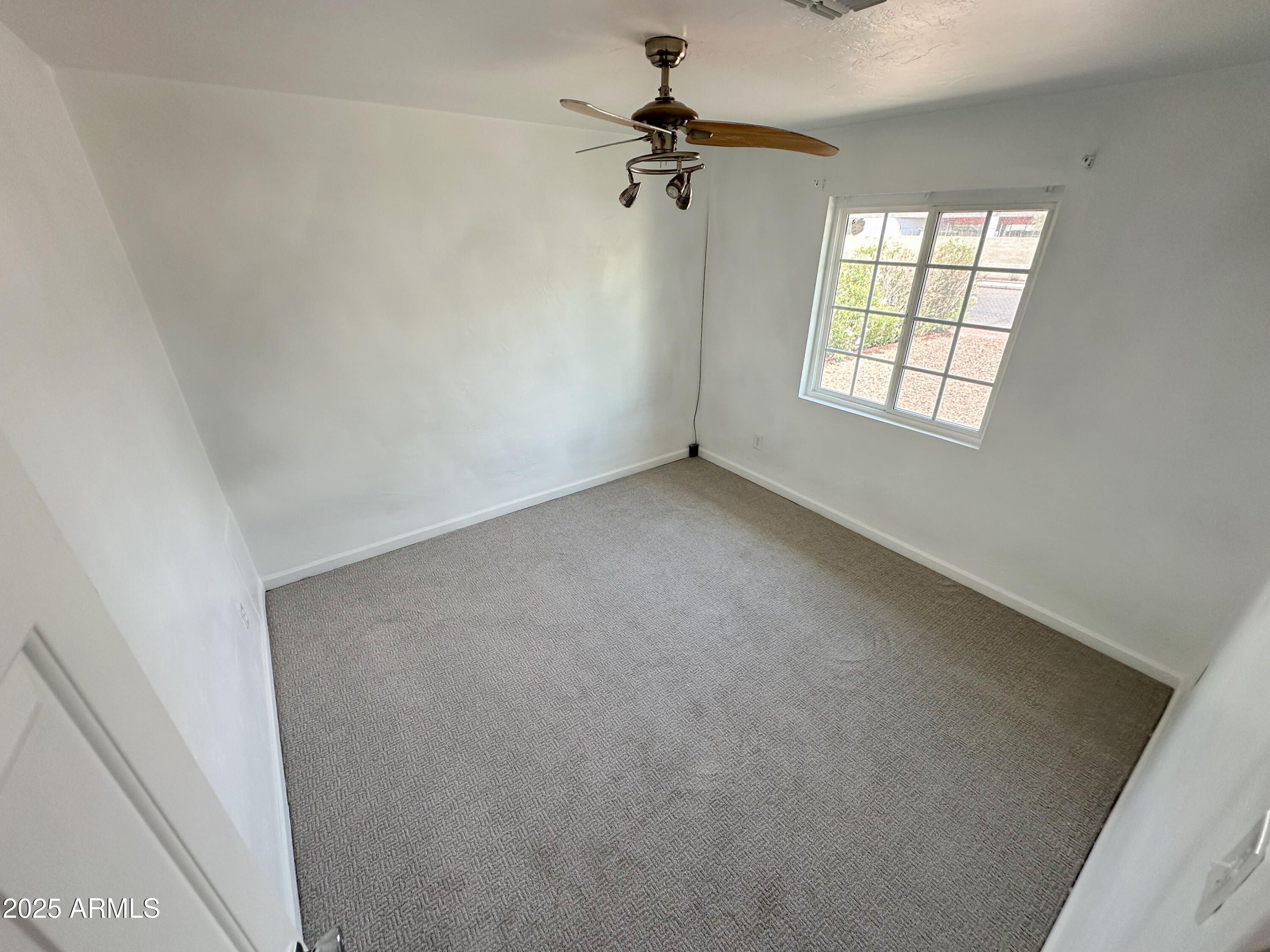 2928 North 37th Avenue Phoenix, AZ 85019 - Photo 9 of 13 an empty room with windows and fan