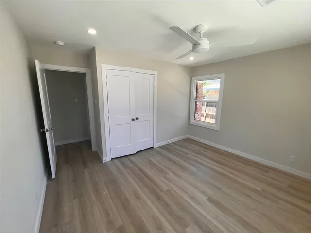 an empty room with wooden floor and a window