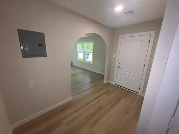 an empty room with wooden floor and windows