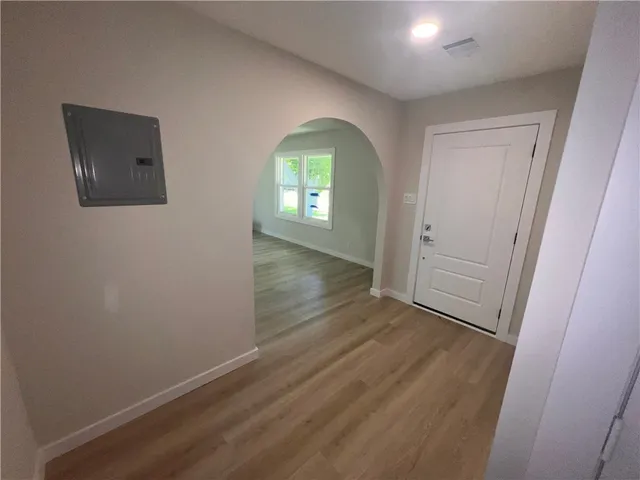 an empty room with wooden floor and windows