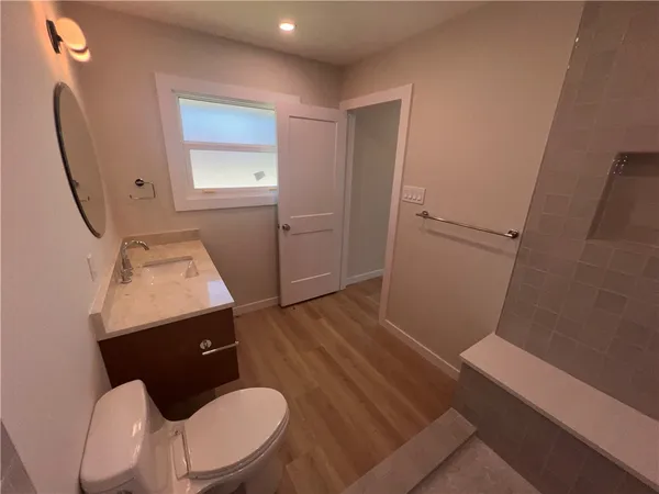a bathroom with a sink mirror and toilet