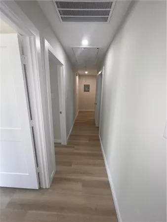 a view of a hallway with wooden floor and staircase
