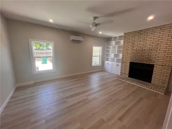 an empty room with windows and a fireplace