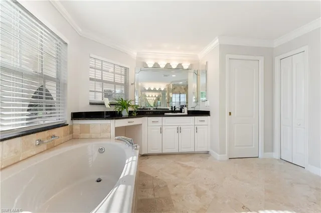 a bathroom with a large tub sink and window
