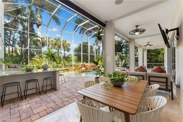 a view of a patio with table and chairs potted plants and floor to ceiling window and wooden floor