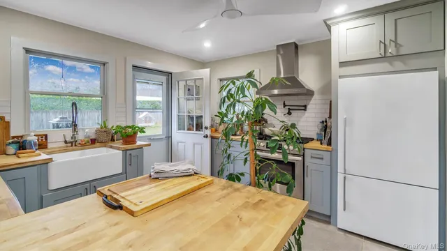 a kitchen with kitchen island granite countertop a sink a stove and cabinets
