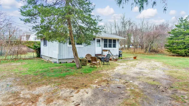 a view of a house with a big yard and large trees