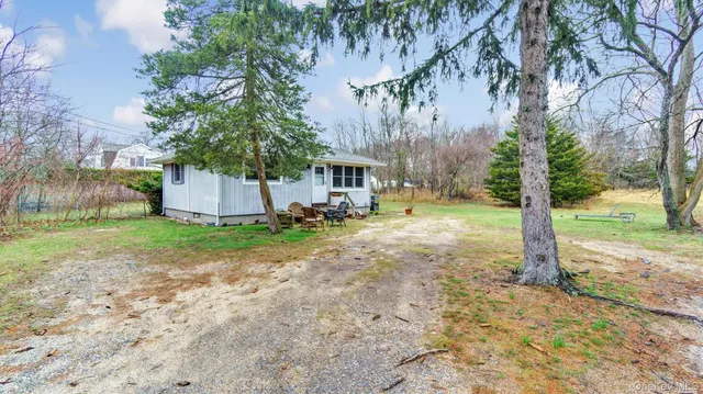 a view of a house with a yard and potted plants