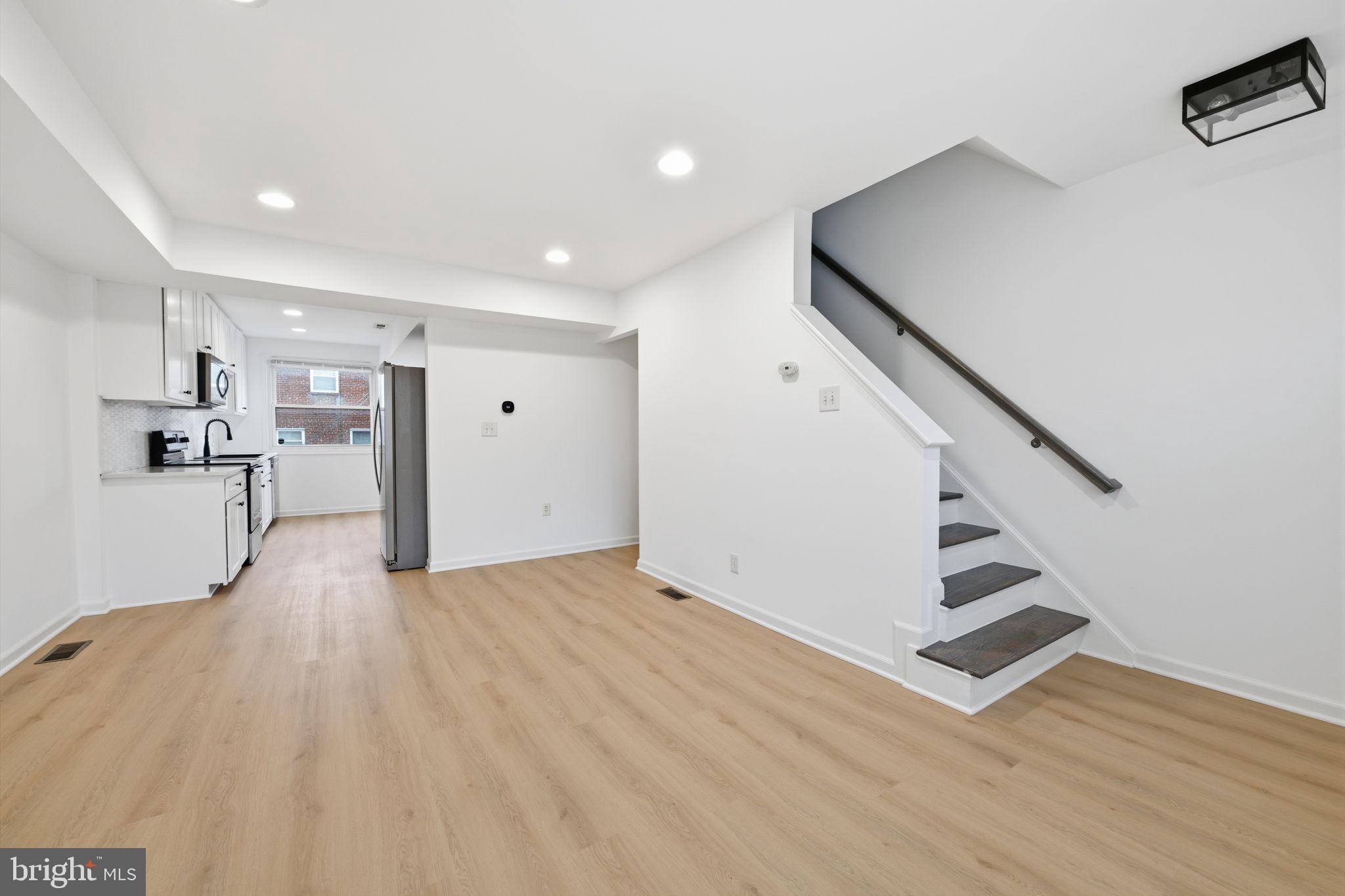 a view of a kitchen with wooden floor and stairs