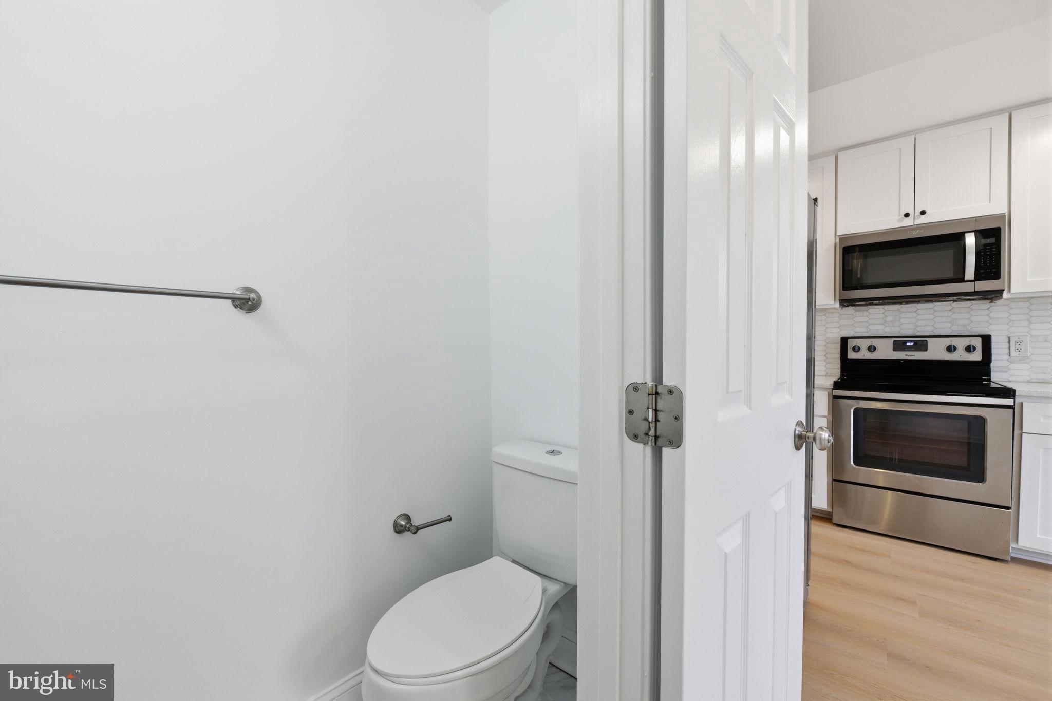 2242 16th Street Northeast Washington, DC 20018 - Photo 15 of 41 a bathroom with a toilet a sink and mirror