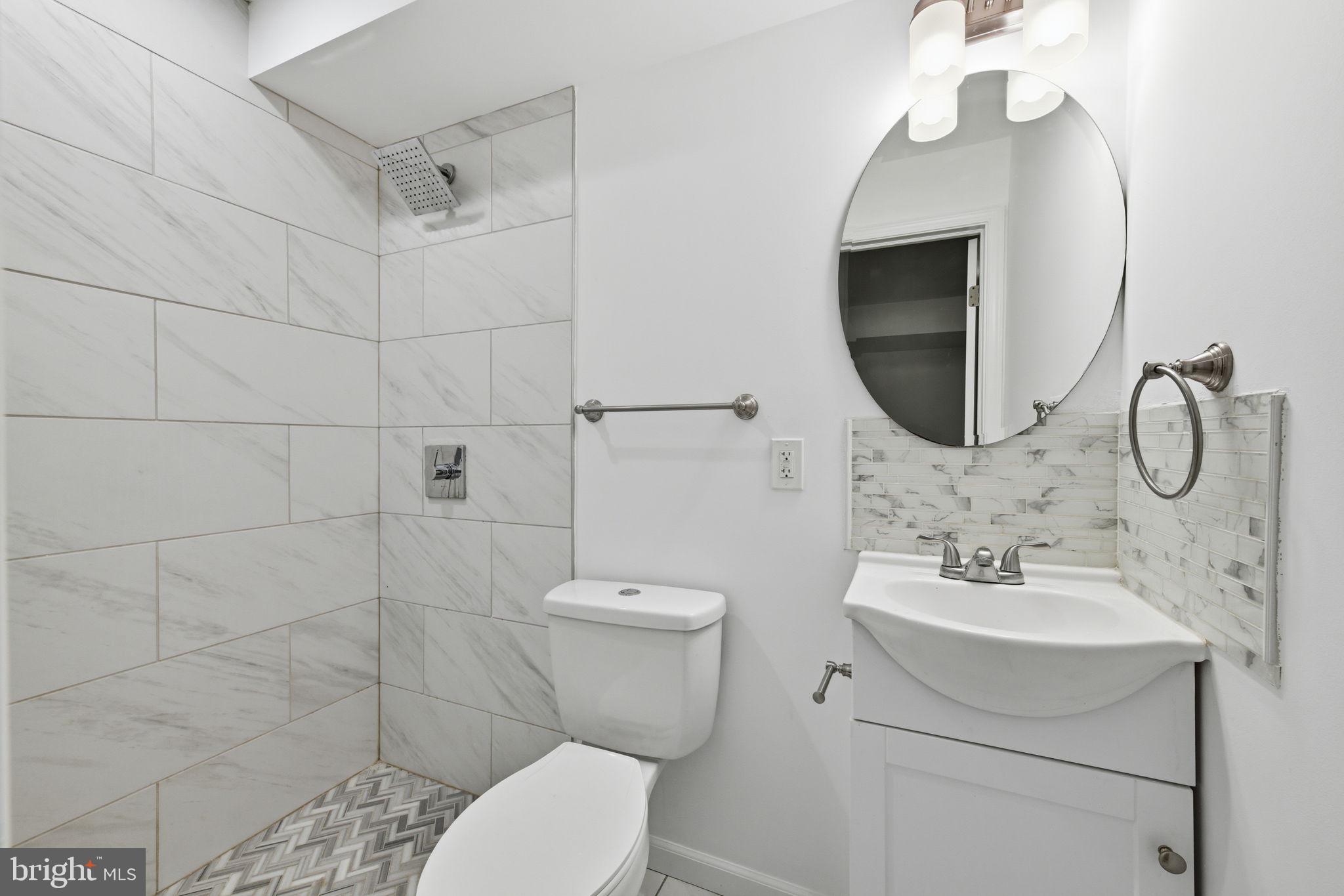 2242 16th Street Northeast Washington, DC 20018 - Photo 17 of 41 a bathroom with a toilet sink and mirror