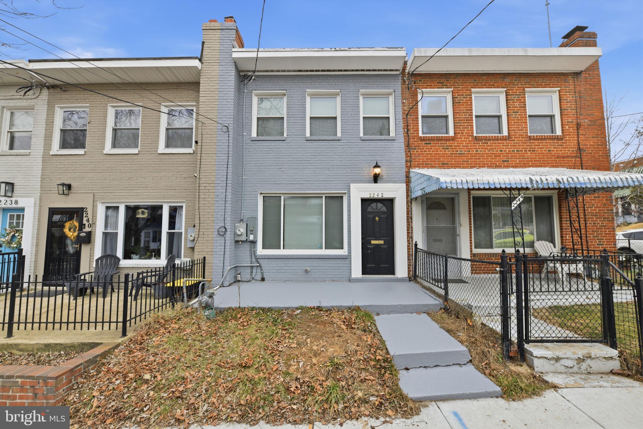 2242 16th Street Northeast Washington, DC 20018 - Photo 5 of 41 front view of a brick house with a chairs and table in a patio