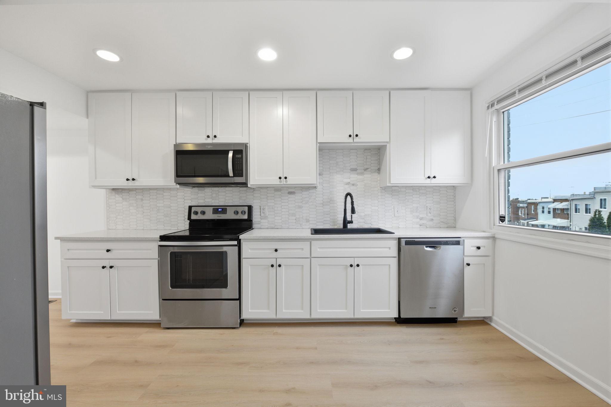 2242 16th Street Northeast Washington, DC 20018 - Photo 10 of 41 a kitchen with cabinets stainless steel appliances and a sink