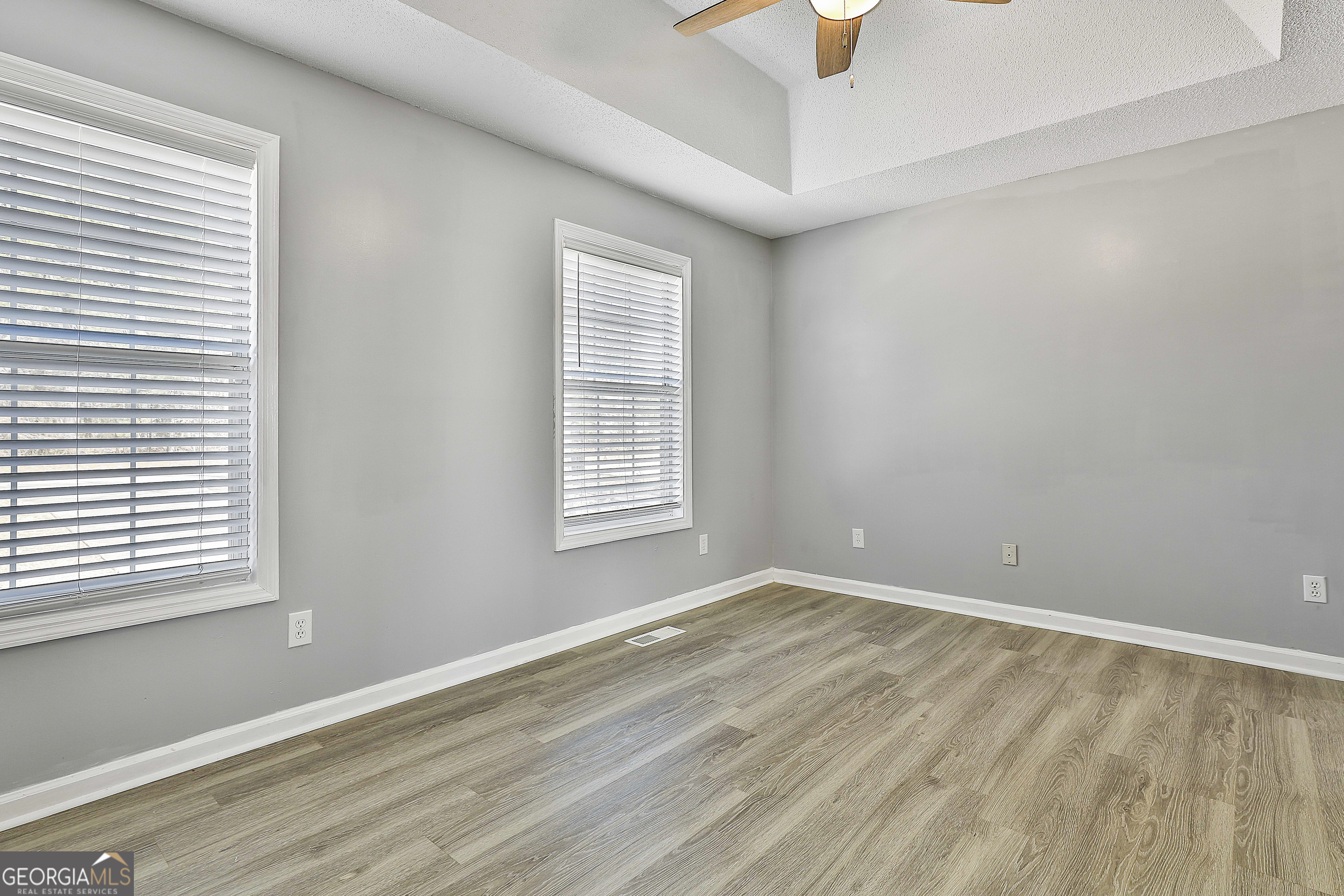 1209 North Hampton Drive Hampton, GA 30228 - Photo 19 of 39 an empty room with windows and a ceiling fan