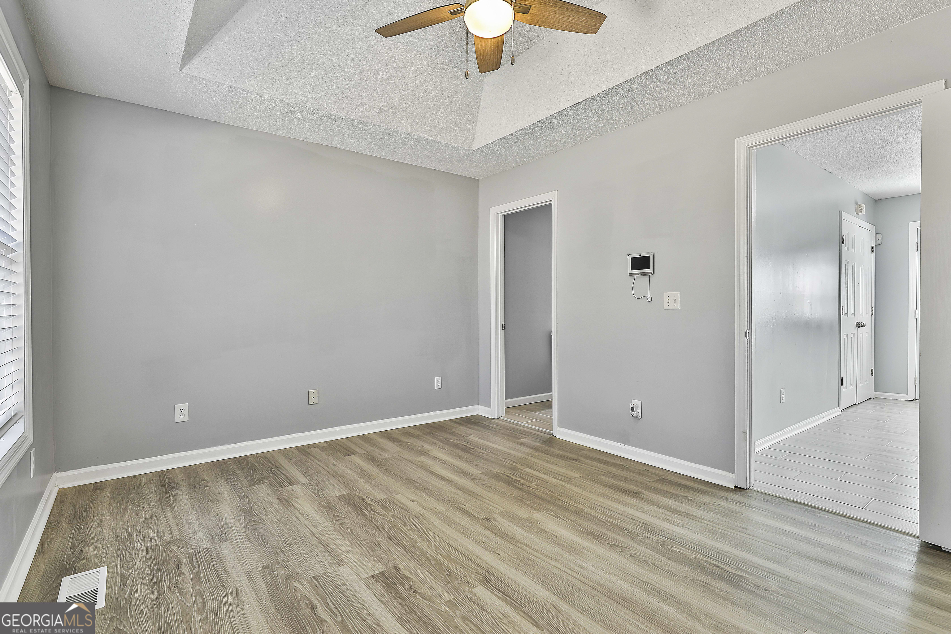 1209 North Hampton Drive Hampton, GA 30228 - Photo 20 of 39 wooden floor in an empty room with a chandelier fan