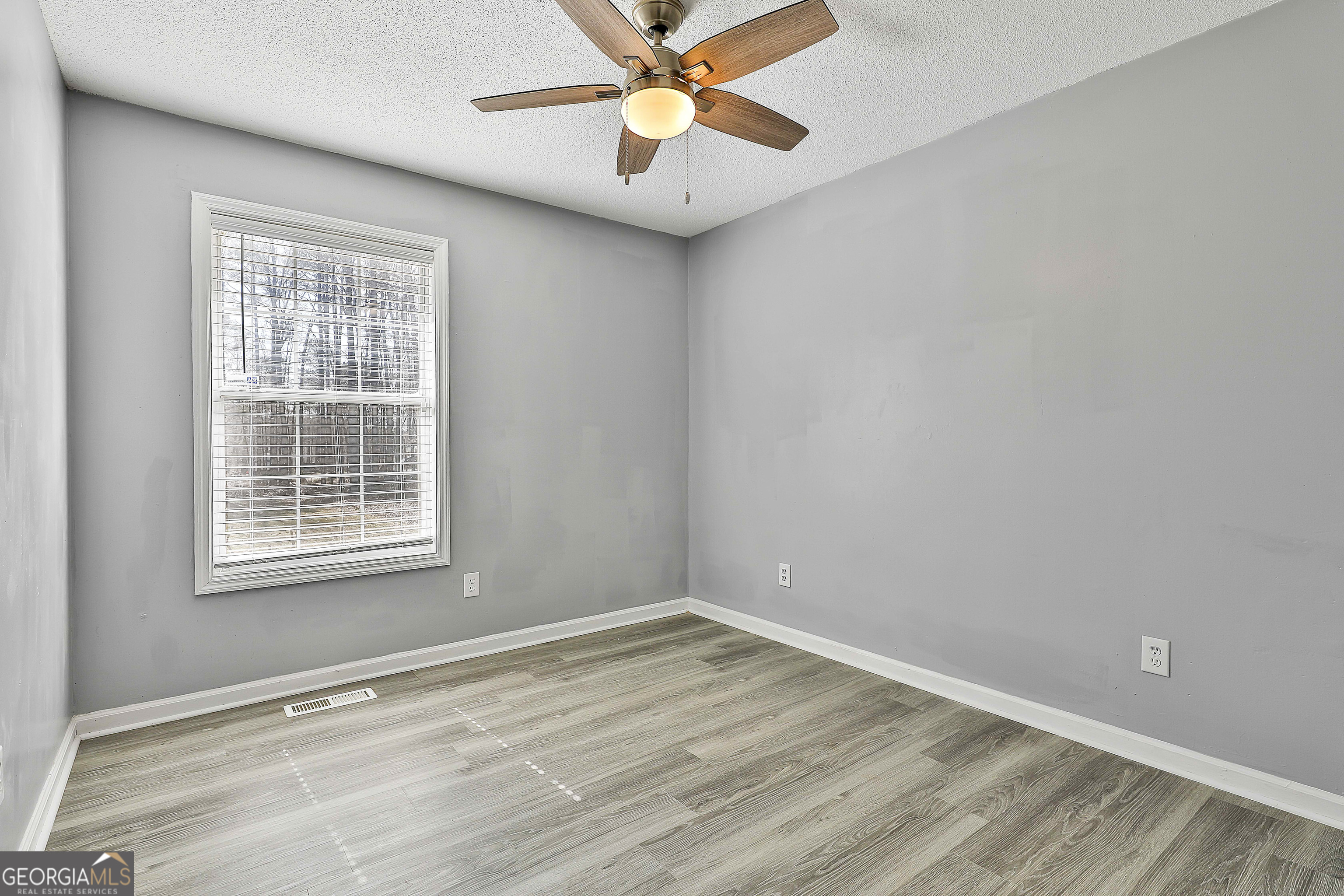 1209 North Hampton Drive Hampton, GA 30228 - Photo 24 of 39 a view of an empty room with window and a chandelier fan